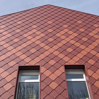 Ce projet s’inscrit comme une prouesse technique et esthétique, car les architectes des Bâtiments de France ont permis à l'atelier d'architecture PANTHEONS by Charlotte Dumas, d’utiliser un nouveau matériau "les losanges de façade en aluminium de PREFA" (en collaboration avec l'entreprise Griffet qui a assuré la pose sur le chantier), tout en respectant la zone et l’harmonie historique du site.